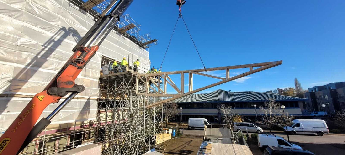Monopitch trusses being craned into a building