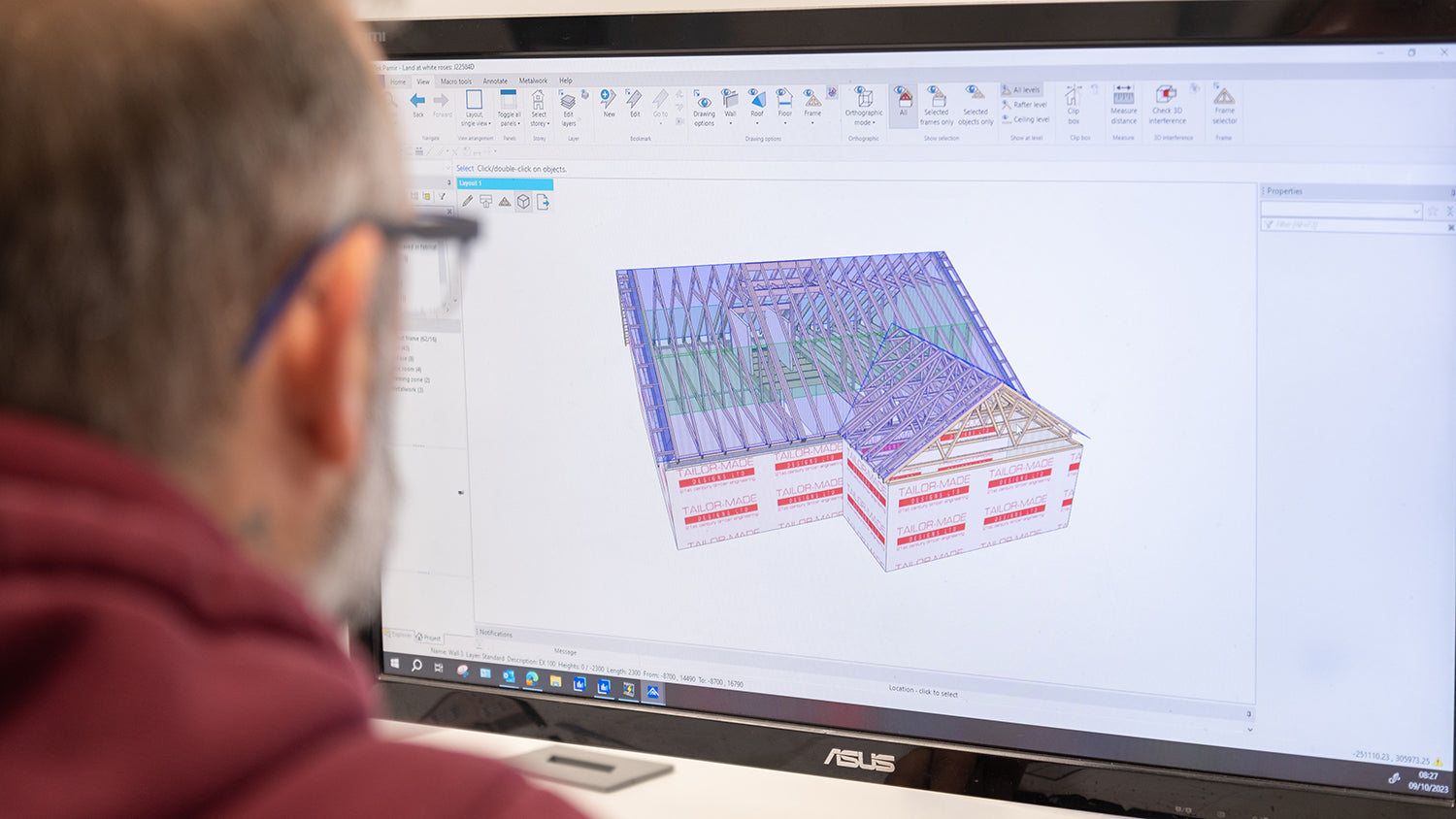 Person using a computer with a 3D architectural model displayed on the screen