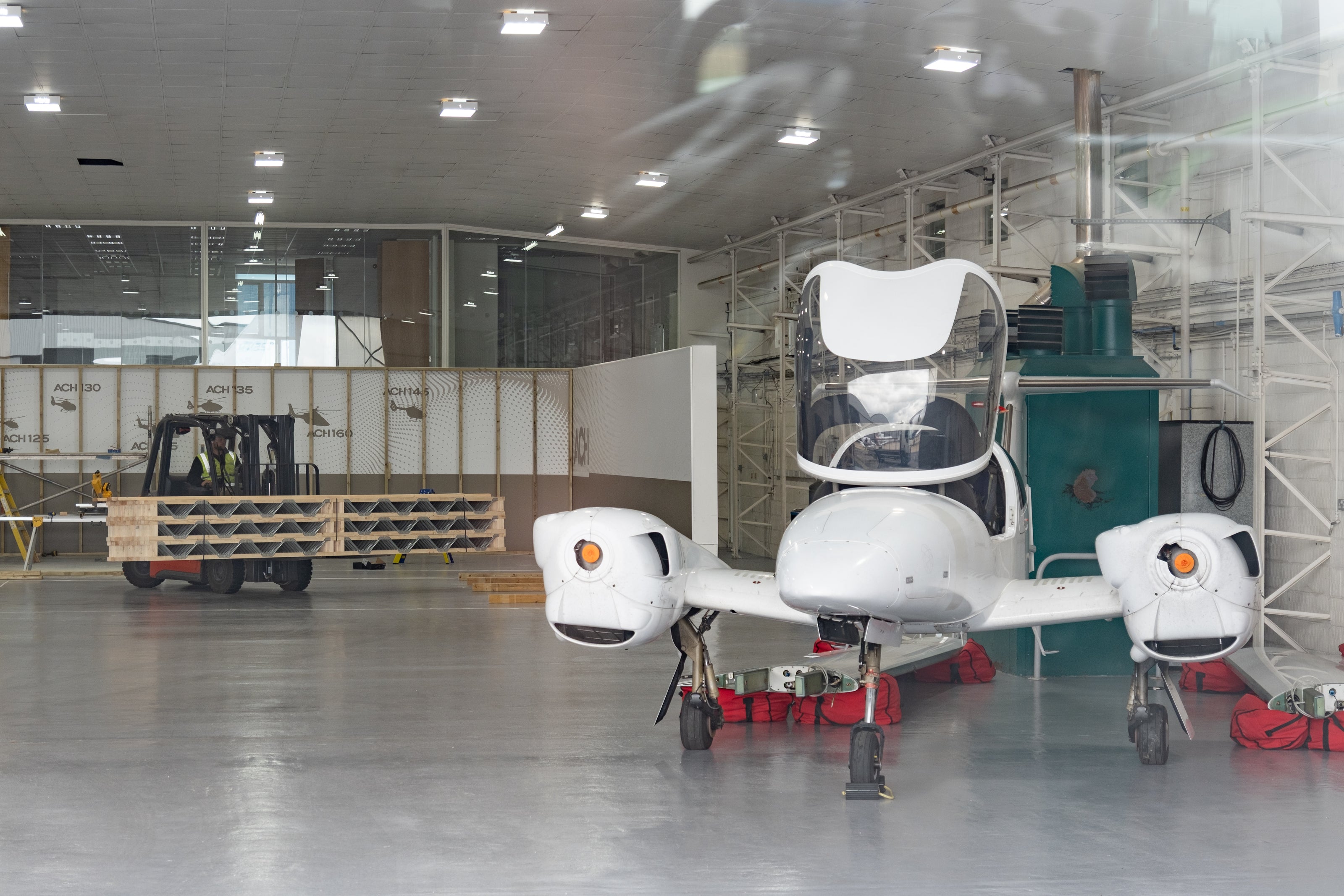 aircraft inside hangar with forklift moving posi-joists behind