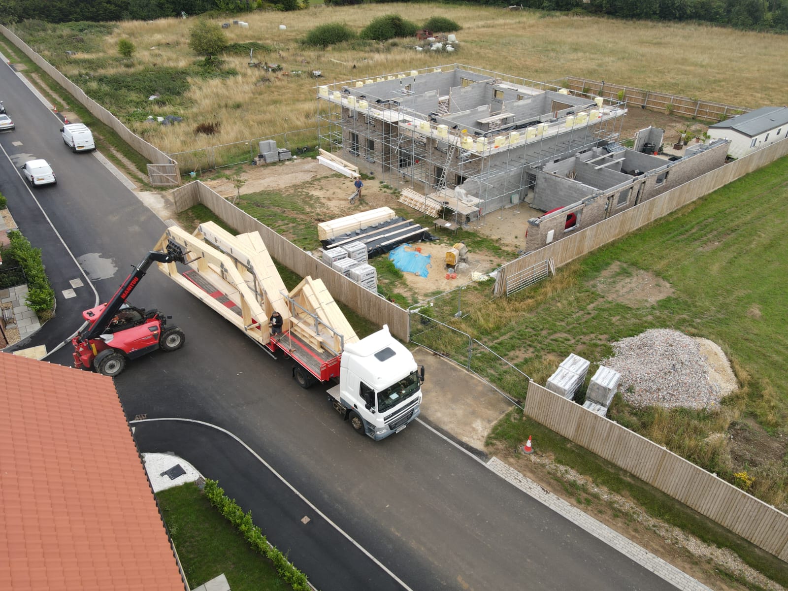 birds eye view of attic trusses being lowered onto a building