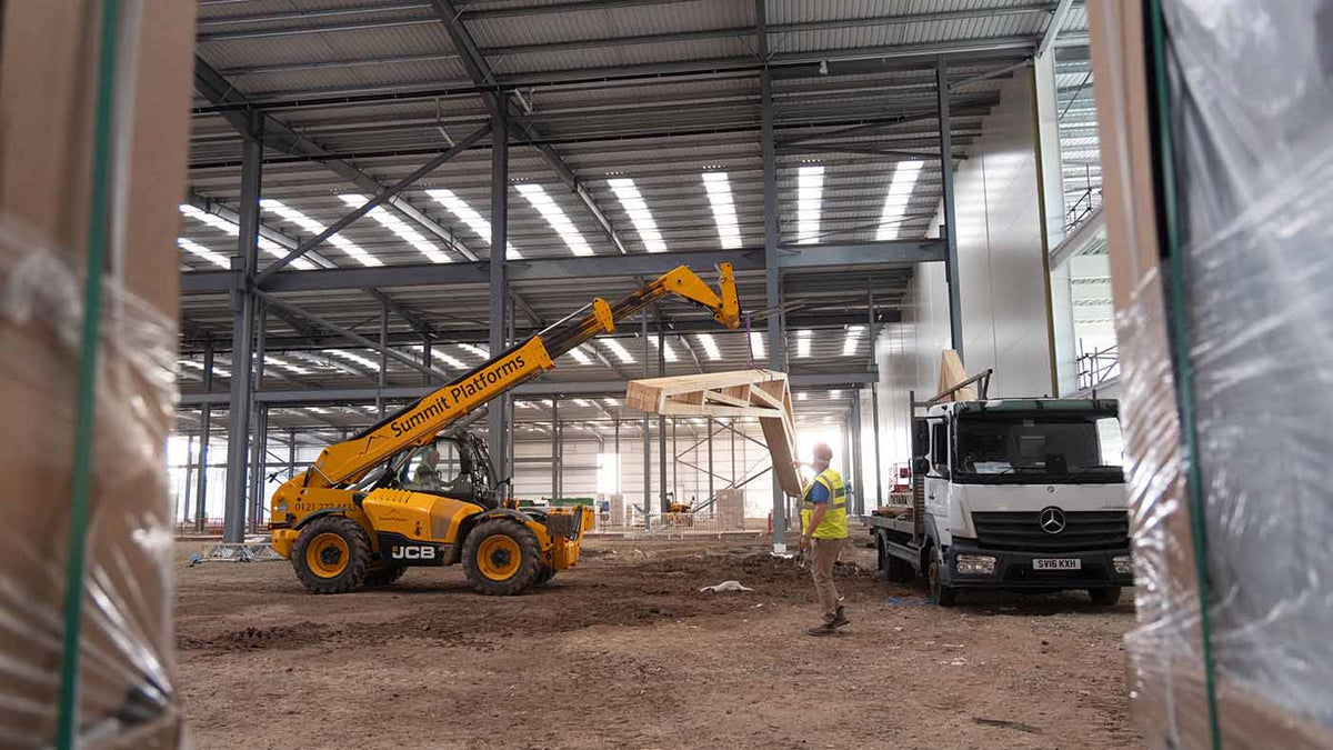 scissor trusses being offloaded from a lorry in a warehouse