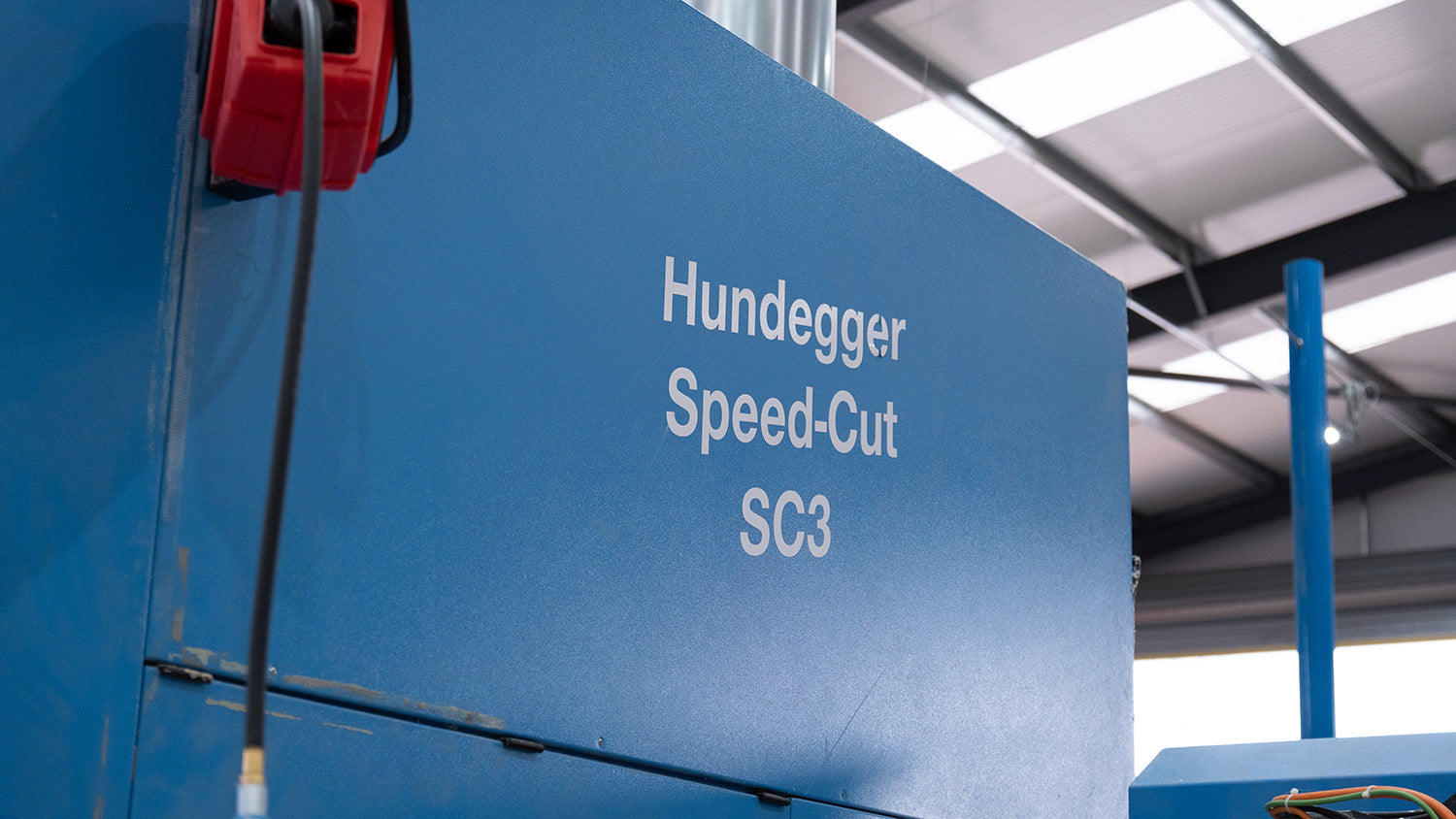 a blue hundegger saw in a factory