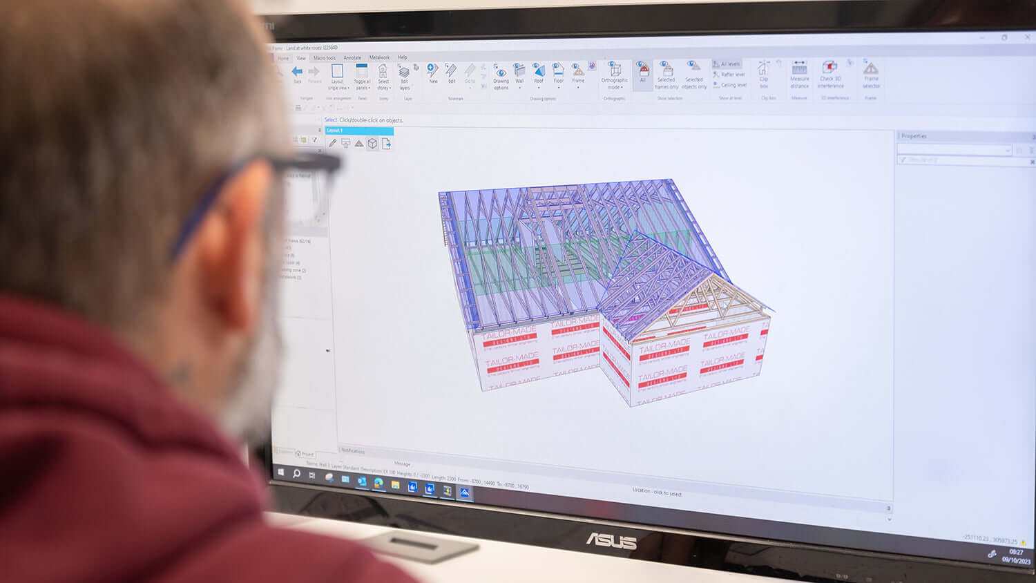 Person using a computer with a 3D architectural model displayed on the screen