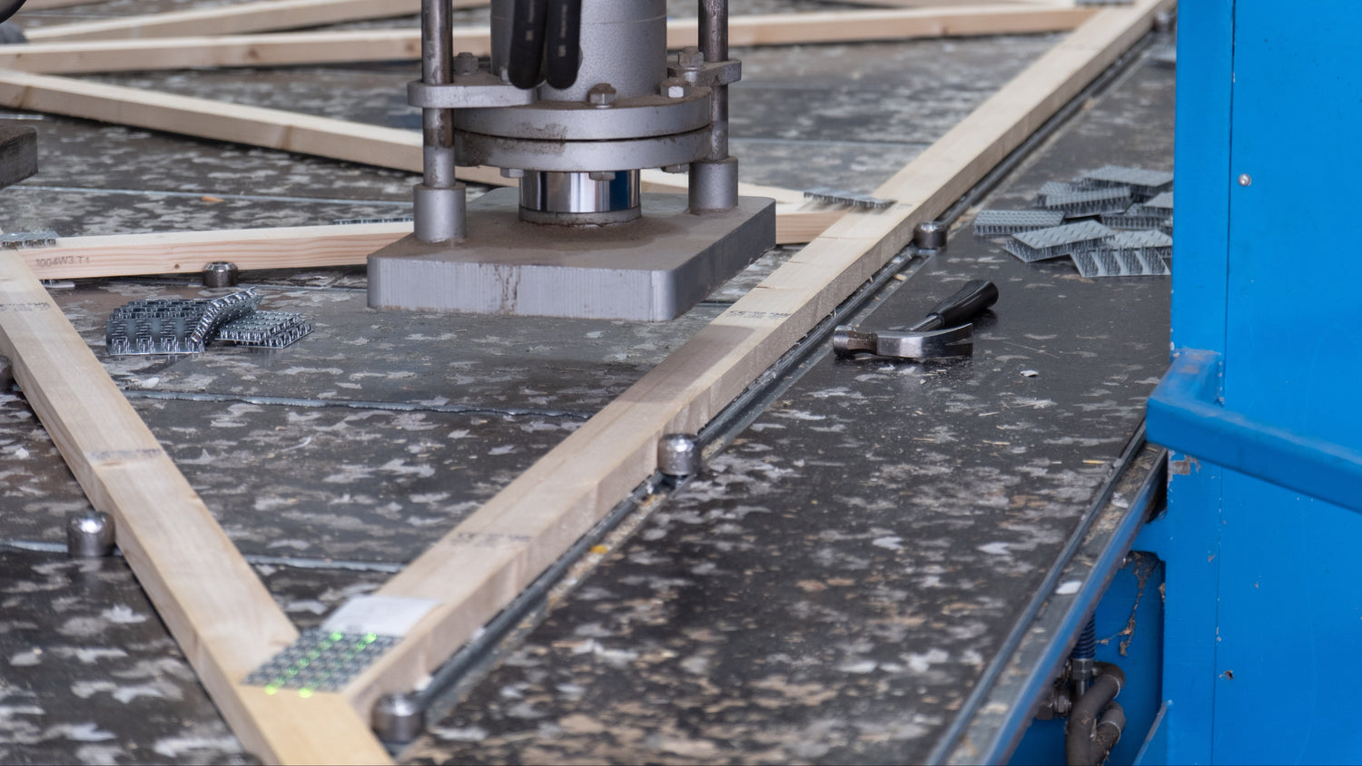a truss press ready to press a nailplate into a wooden roof truss