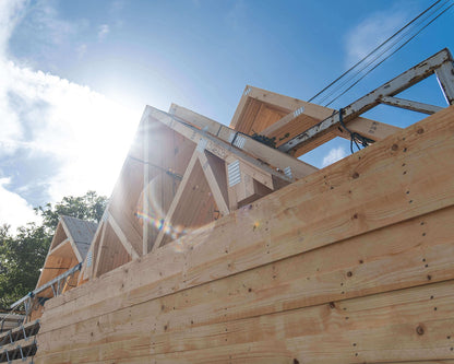 close up view of roof trusses on a lorry with blue sky and sunshine behind